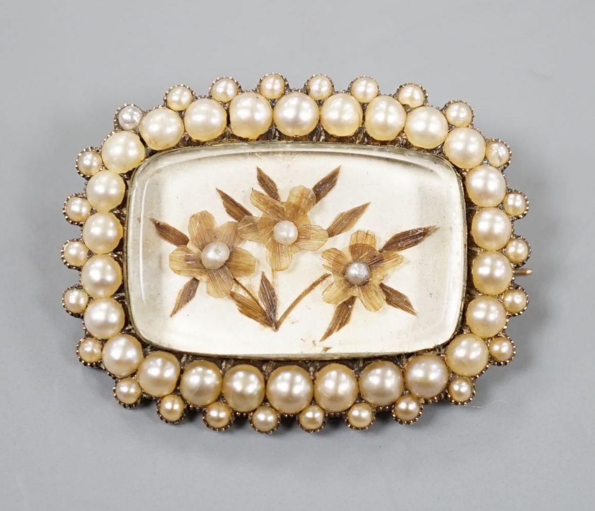 A 19th century yellow metal and seed pearl brooch, with glazed floral motif, 31mm, gross weight 6.1 grams.